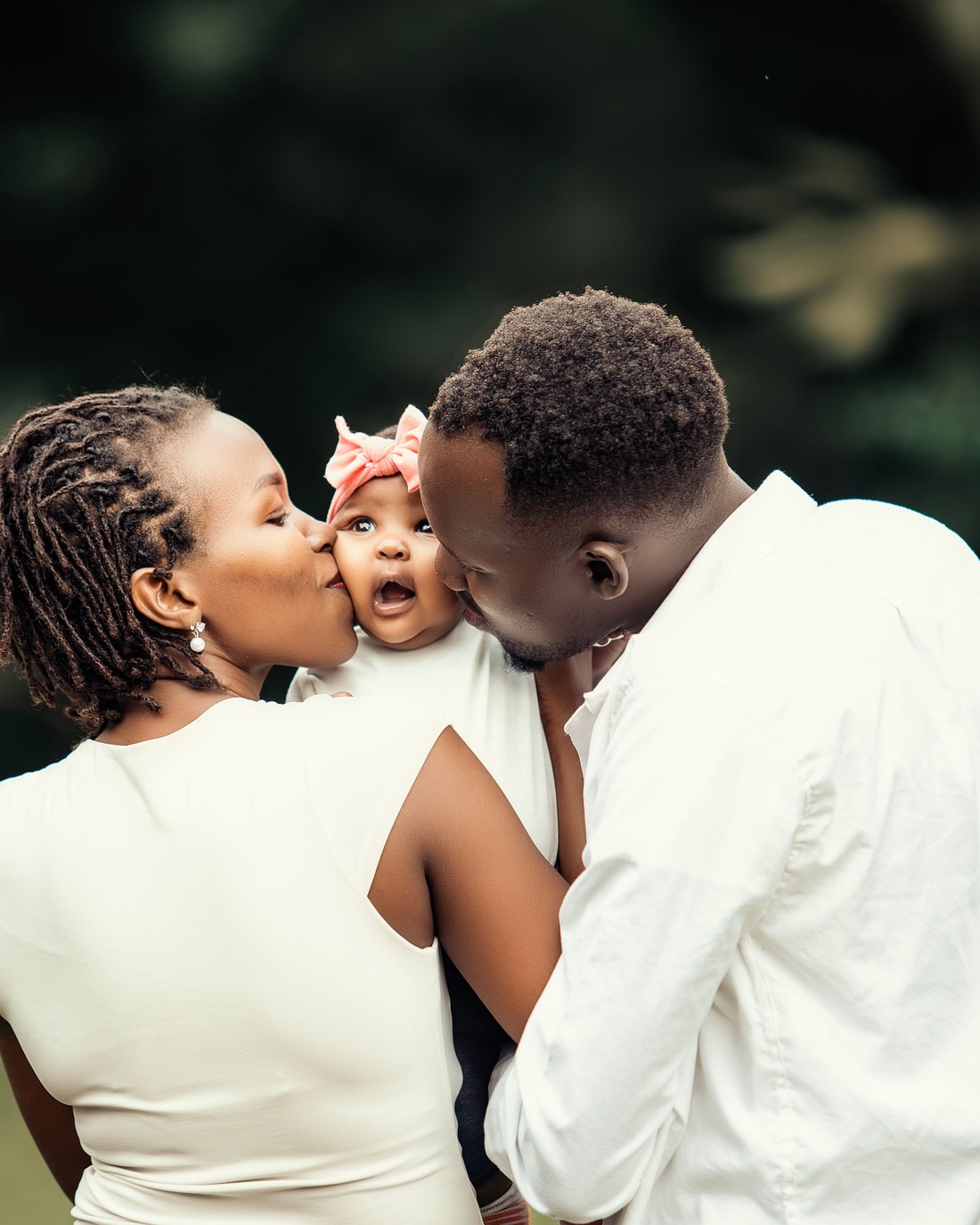 Parents kissing their baby, on a photobook cover